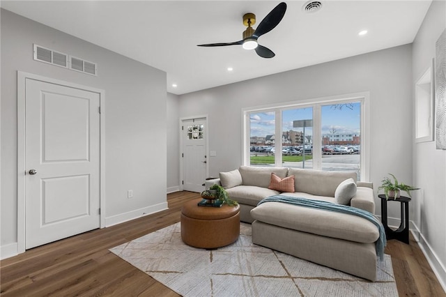 sitting room with baseboards, wood finished floors, visible vents, and ceiling fan