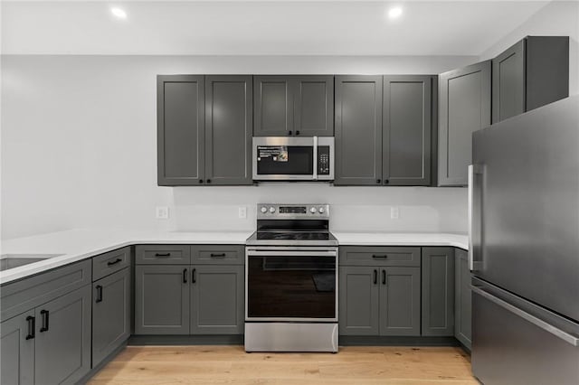 kitchen featuring light countertops, recessed lighting, appliances with stainless steel finishes, and gray cabinets