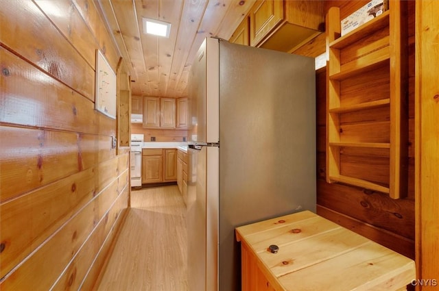 kitchen with light brown cabinets, range, light wood finished floors, light countertops, and freestanding refrigerator