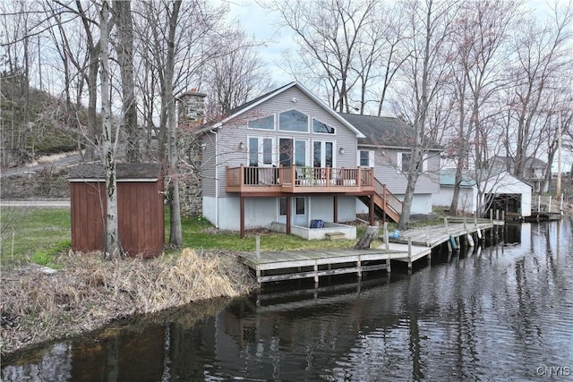 14 Renshaw Bay Rd, Sandy Creek, NY 13145 - back of property with stairway, a chimney, a deck with water view, an outbuilding, and a storage unit