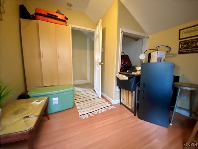 interior space featuring vaulted ceiling and light wood-style floors