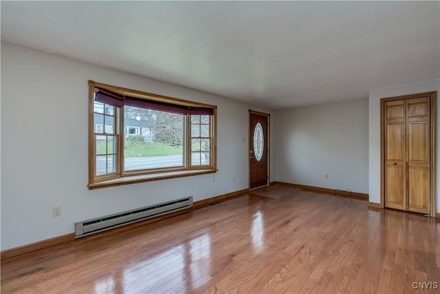 unfurnished living room featuring a baseboard radiator, baseboards, and light wood-style flooring
