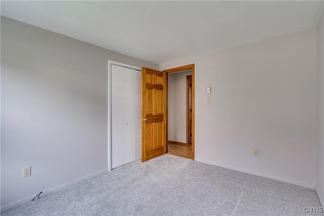 unfurnished room with baseboards and carpet flooring