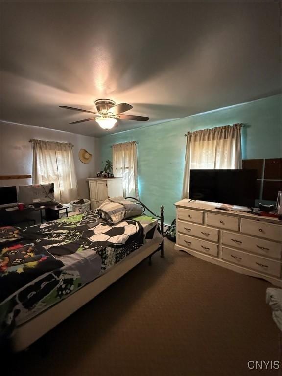 bedroom featuring ceiling fan and dark colored carpet