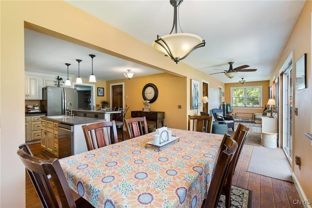 dining area with a ceiling fan, baseboards, and dark wood finished floors