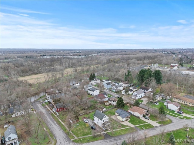 drone / aerial view featuring a wooded view and a residential view