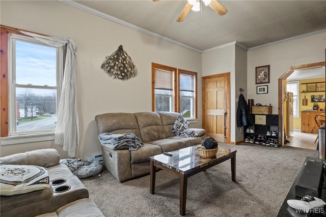 living room with ornamental molding, arched walkways, a baseboard radiator, carpet flooring, and ceiling fan