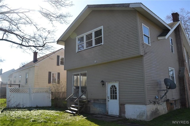 2386 Main St, Collins, NY 14034 - rear view of house with a chimney, fence, entry steps, and a lawn