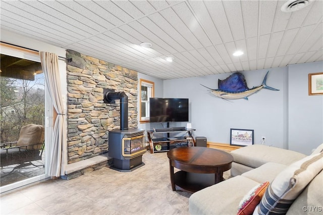 living area featuring visible vents and a wood stove