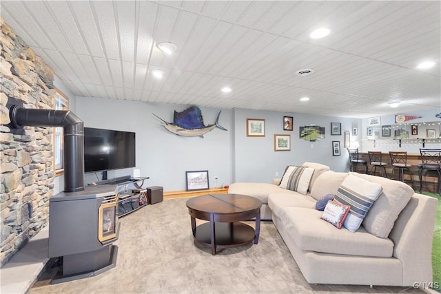 living room with recessed lighting, bar area, and a wood stove