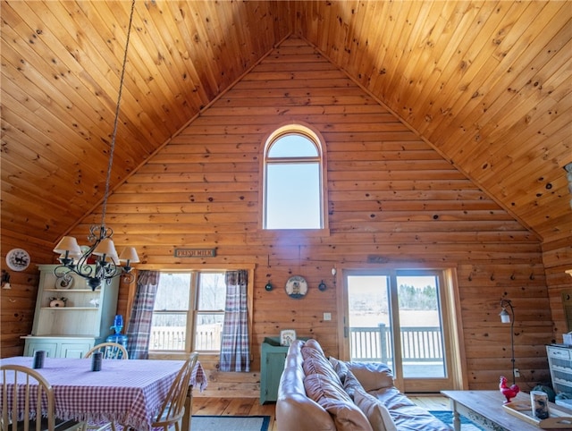 living area with high vaulted ceiling, hardwood / wood-style flooring, wood ceiling, an inviting chandelier, and wood walls