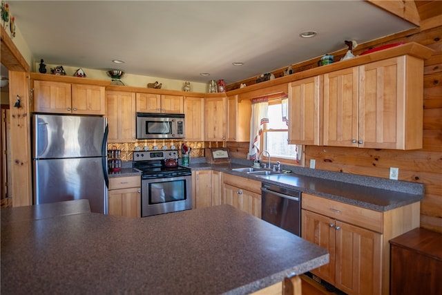 kitchen featuring light brown cabinets, dark countertops, a sink, decorative backsplash, and stainless steel appliances