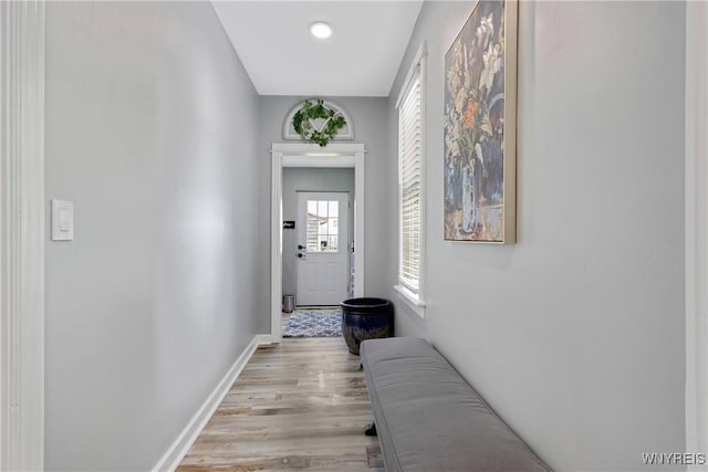 hallway featuring light wood-style flooring and baseboards