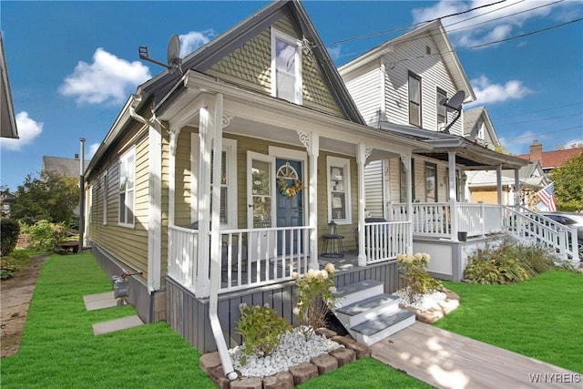 shotgun-style home with covered porch and a front yard