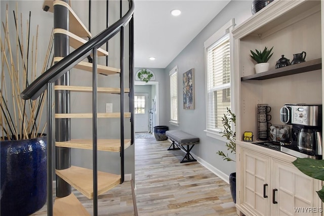 staircase featuring baseboards, wood finished floors, and recessed lighting