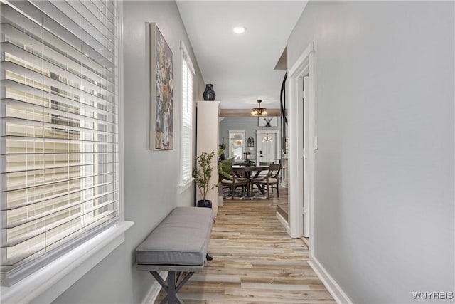 hall featuring light wood finished floors, baseboards, and recessed lighting