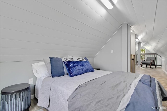 bedroom with vaulted ceiling and wood finished floors
