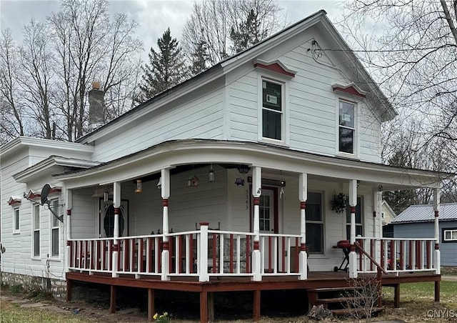 farmhouse with a porch and a chimney