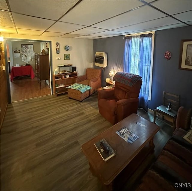 living room featuring heating unit, a paneled ceiling, and wood finished floors