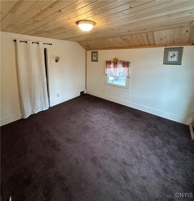 spare room featuring lofted ceiling, wooden ceiling, baseboards, and dark carpet