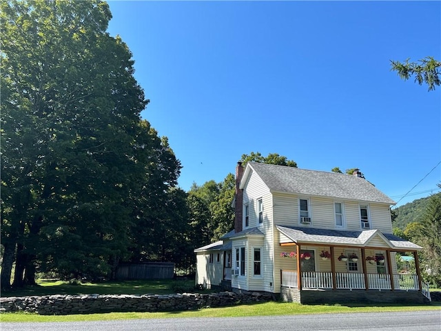 farmhouse featuring a chimney and covered porch