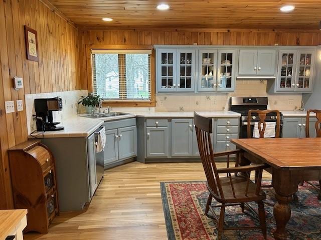 kitchen with gray cabinets, a sink, light wood-type flooring, wood ceiling, and appliances with stainless steel finishes