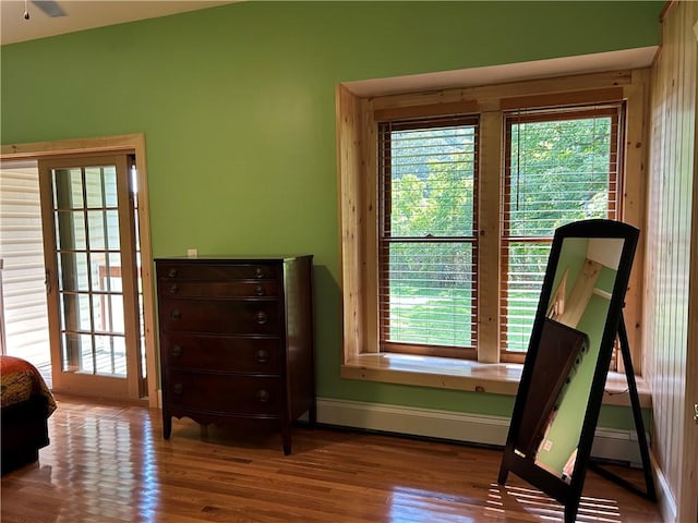 bedroom featuring a baseboard radiator, baseboards, and wood finished floors