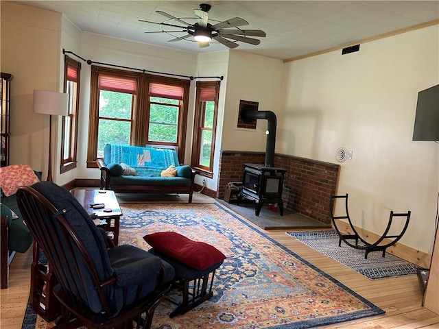 living room featuring wood-type flooring, visible vents, a ceiling fan, and baseboards