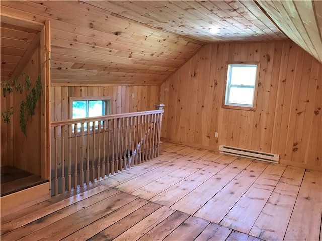 bonus room with a baseboard heating unit, lofted ceiling, hardwood / wood-style floors, and wooden walls