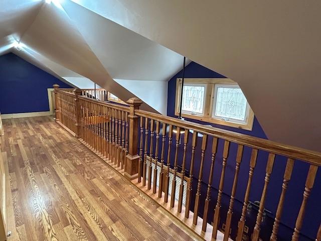 additional living space with lofted ceiling, wood finished floors, and baseboards