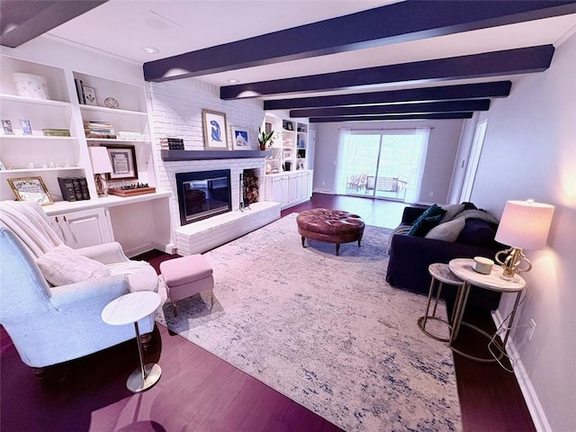 living area featuring baseboards, built in shelves, beamed ceiling, wood finished floors, and a fireplace