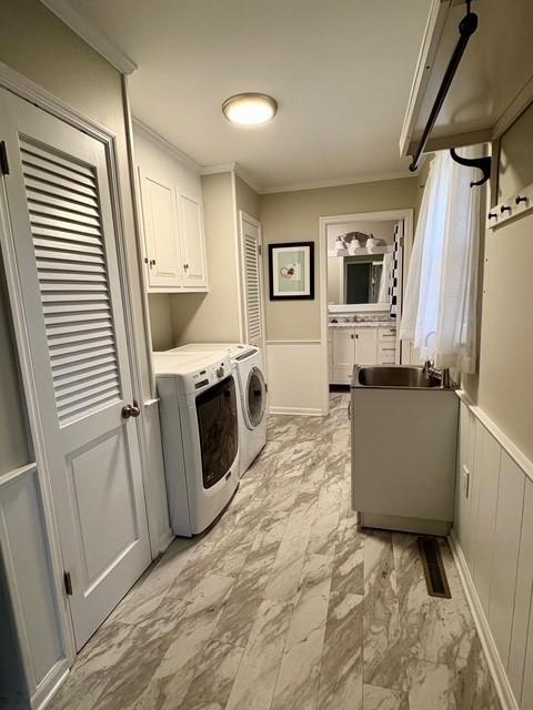 laundry room featuring crown molding, a sink, separate washer and dryer, marble finish floor, and cabinet space