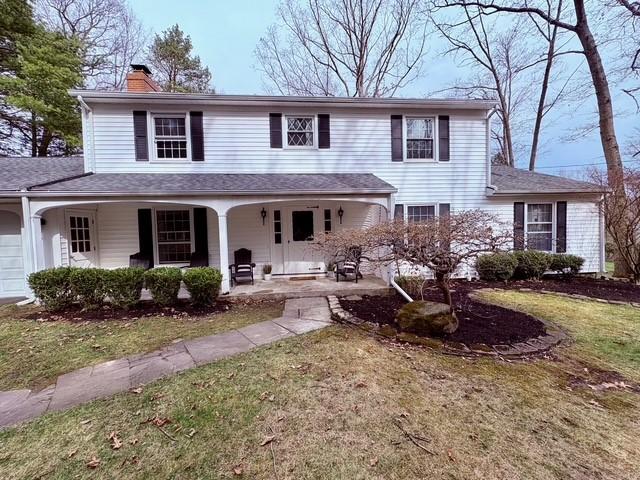 view of front of house featuring a chimney, a front yard, and a garage