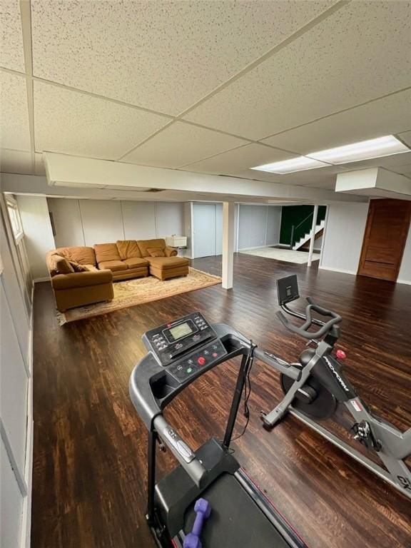 exercise room featuring a paneled ceiling and wood finished floors