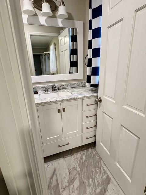 bathroom with marble finish floor and vanity