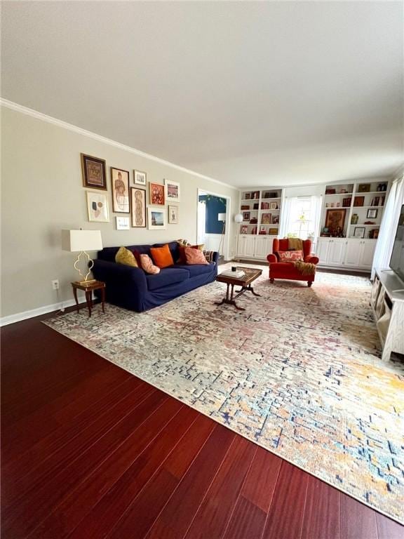 living room featuring baseboards, crown molding, built in features, and wood finished floors