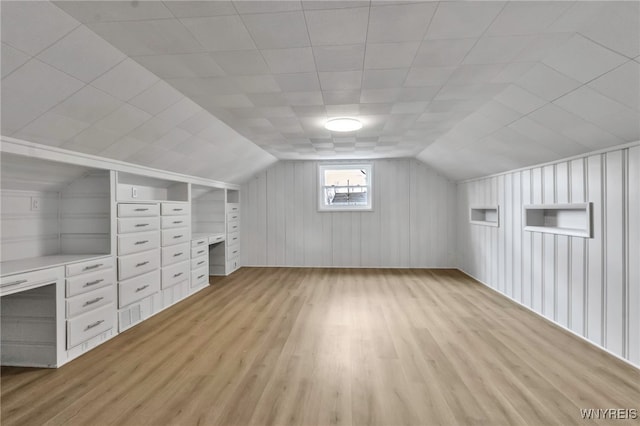 additional living space featuring light wood-style floors and vaulted ceiling