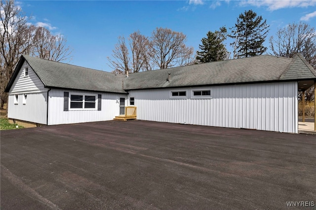 back of house with a shingled roof