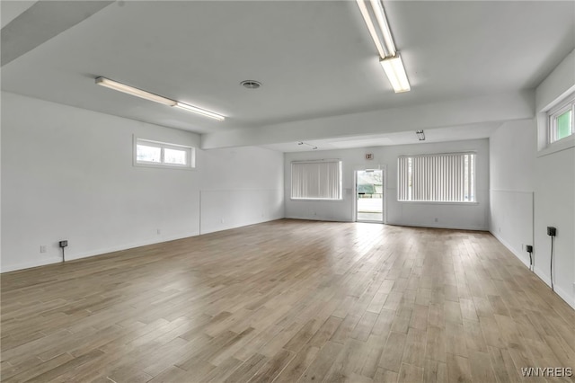 spare room with baseboards, light wood-style flooring, and visible vents