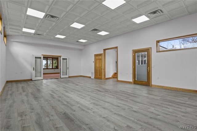 unfurnished room featuring wood finished floors, visible vents, and baseboards