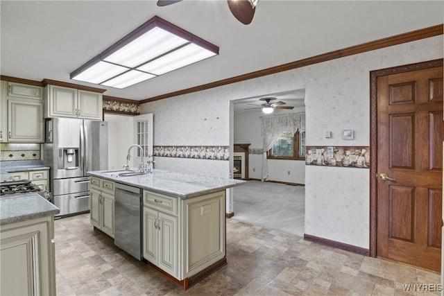 kitchen with ceiling fan, a sink, cream cabinetry, and appliances with stainless steel finishes