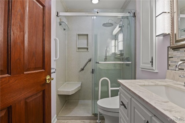 full bathroom featuring backsplash, toilet, vanity, ornamental molding, and a stall shower