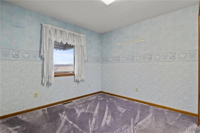 empty room featuring visible vents, carpet flooring, and baseboards