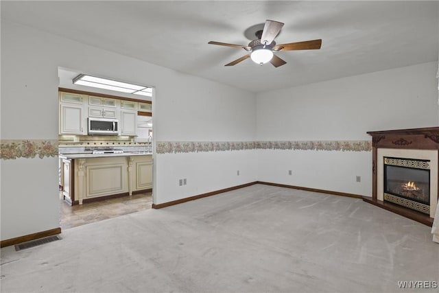 unfurnished living room with light carpet, a ceiling fan, visible vents, and baseboards