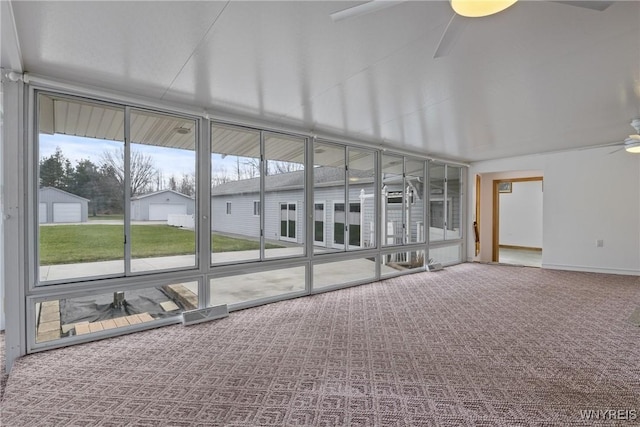 unfurnished sunroom with ceiling fan