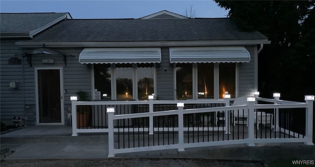 rear view of property featuring a shingled roof