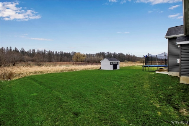 view of yard with a storage unit, an outdoor structure, and a trampoline