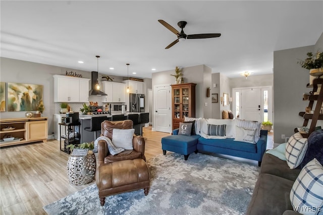 living room featuring recessed lighting, light wood finished floors, and a ceiling fan