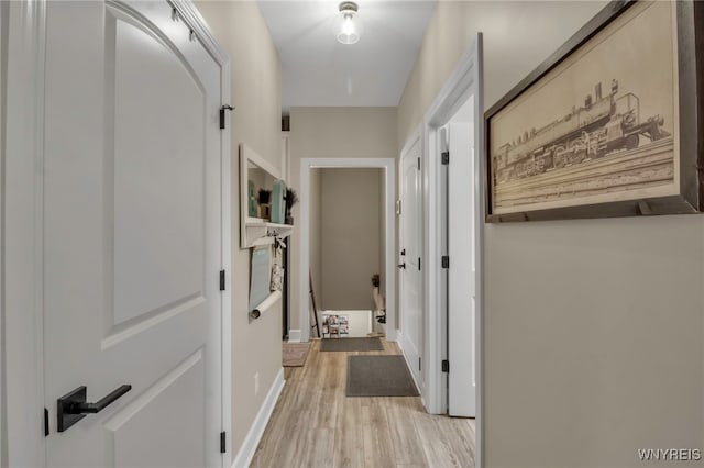 corridor with wood finished floors and baseboards