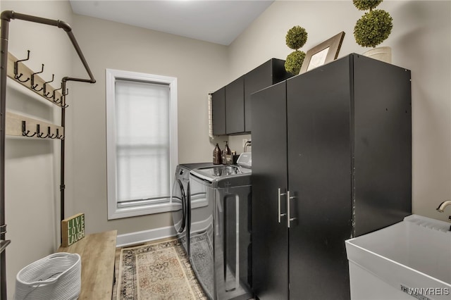 laundry room with washer and clothes dryer, wood finished floors, a sink, cabinet space, and baseboards